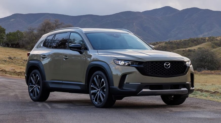 2025 Mazda CX-50 compact SUV driving on a scenic mountain road